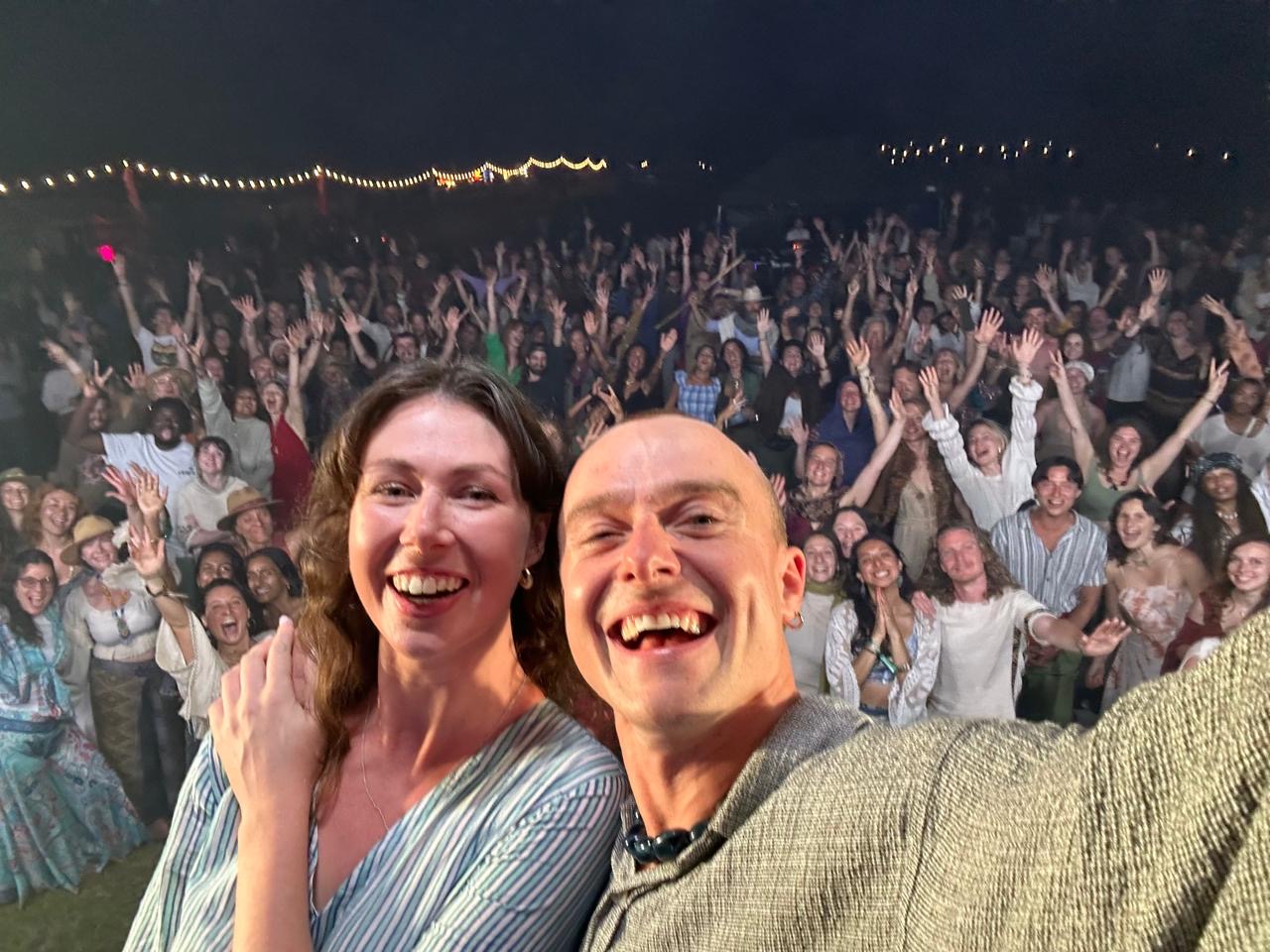 Genevieve and Milo on stage in front of a festival crowd at night